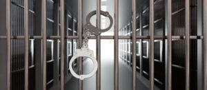 Jail cell and handcuffs representing the consequences of a felony conviction explained by a Chula Vista criminal defense lawyer.