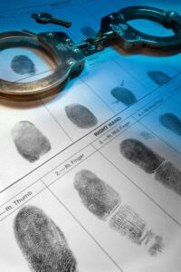 Fingerprint card and legal paperwork representing record expungement services provided by an Encinitas criminal defense attorney.