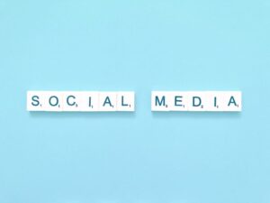 Social media icons on wooden blocks representing online statements discussed by a Carlsbad criminal defense lawyer.