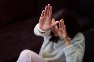 Woman making a stop gesture to symbolize domestic violence awareness, illustrating legal guidance from an Orange County criminal defense attorney.
