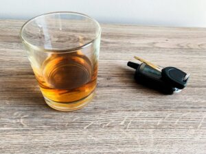 Alcohol glass and car keys on a table, illustrating underage DUI laws explained by a San Diego criminal defense attorney.