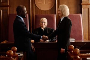 Two El Cajon criminal defense attorney shaking hands in a courtroom while discussing legal representation