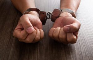 Hands in handcuffs symbolizing a felony arrest and conviction explained by an El Cajon Criminal Defense Attorney.