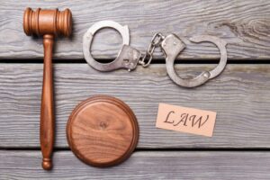 Judge's gavel and criminal handcuffs representing California's Three Strikes Law explained by an Encinitas Criminal Defense Attorney.