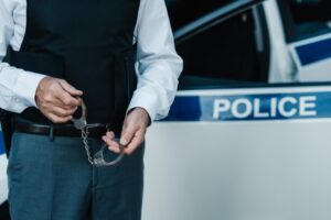 Police officer with criminal handcuffs representing a sex crimes investigation explained by a Coronado criminal defense attorney.